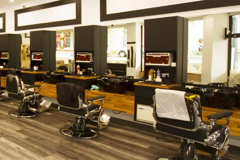 An experienced Tamadon barber carefully shaping a customer’s hairstyle in the Dandenong shop.
